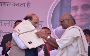 Madhu Pandit Dasa, Chairman felicitating Sri Rajnath Singh, Minister of Home Affairs, with a shawl on stage