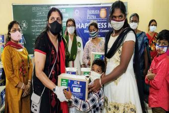 Children accompanied by their parents receive the Happiness Kits 