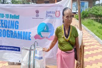 A lady belonging to the local tribe receives relief supplies