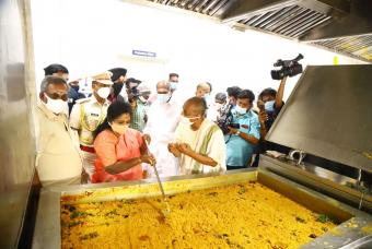 The LG of Puducherry gives a hand to stir the curry cooked in a large quantity