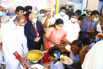 Young children receive their share of cooked meals from the dignitaries