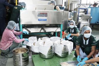 Akshaya Patra’s kitchen staff preparing the food carrier vessels 