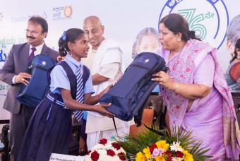 One of the beneficiaries receives school bag from the guests at the inaugural ceremony.