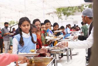 Young children receiving meals after the inauguration ceremony