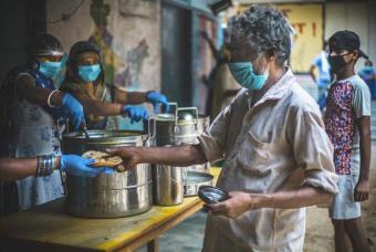 Freshly cooked rotis being handed over to a daily-wage worker.