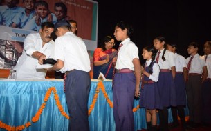 Children stand in queue as they receive shoes from Pramod Sharma of Lucknow Municipal Corporation