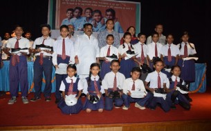 The beneficiaries of the TOMS-Akshaya Patra partnership along with dignitaries on stage