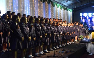 A school choir sings an invocation during the event